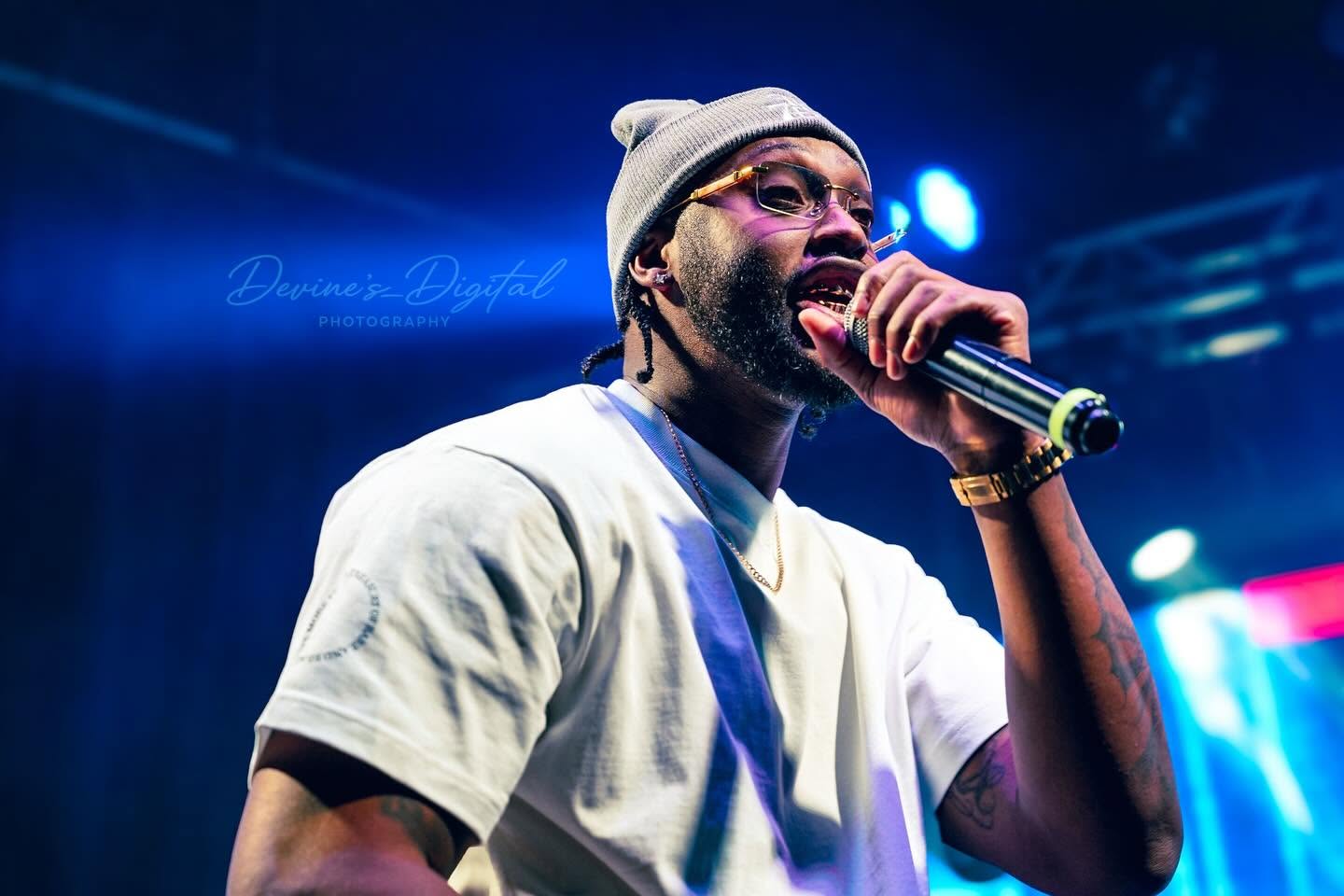 JayDubb Tha Ruler performs with a microphone under blue lights