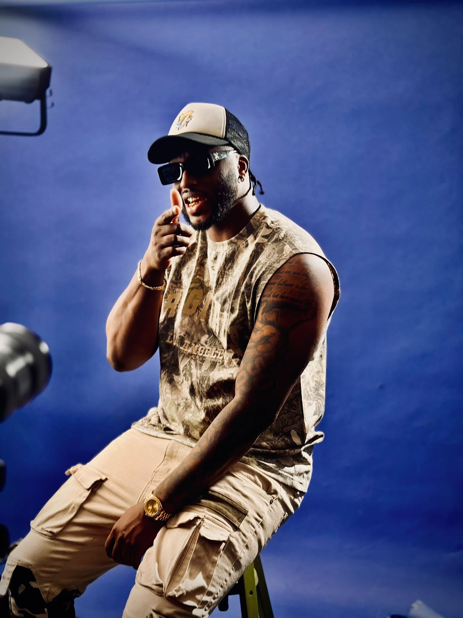 JayDubb Tha Ruler holding a microphone under blue stage lights